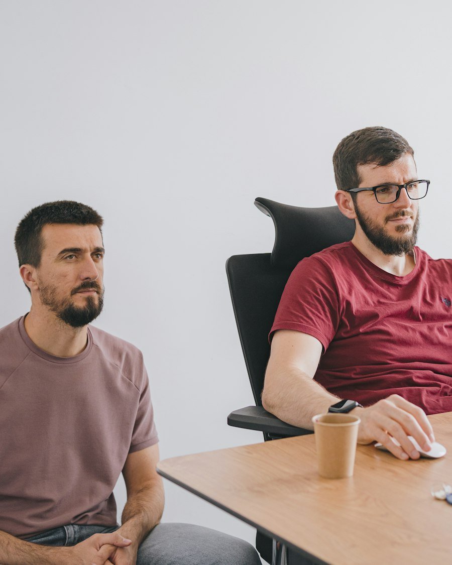 Two colleagues talking something through at a laptop.